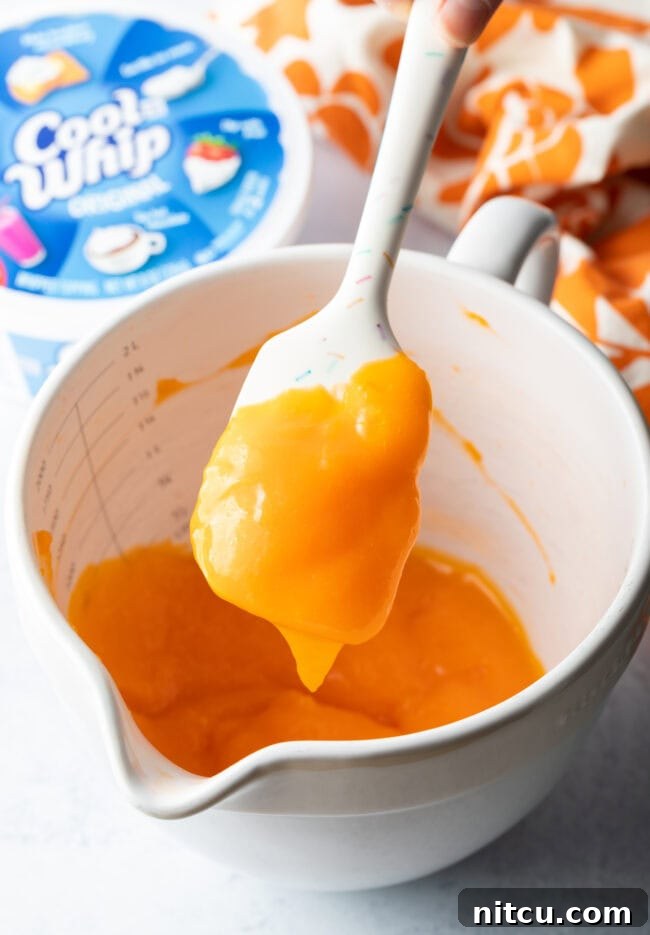 Zesty Orange Ambrosia 7 Pudding and jello mix combined in a white bowl.