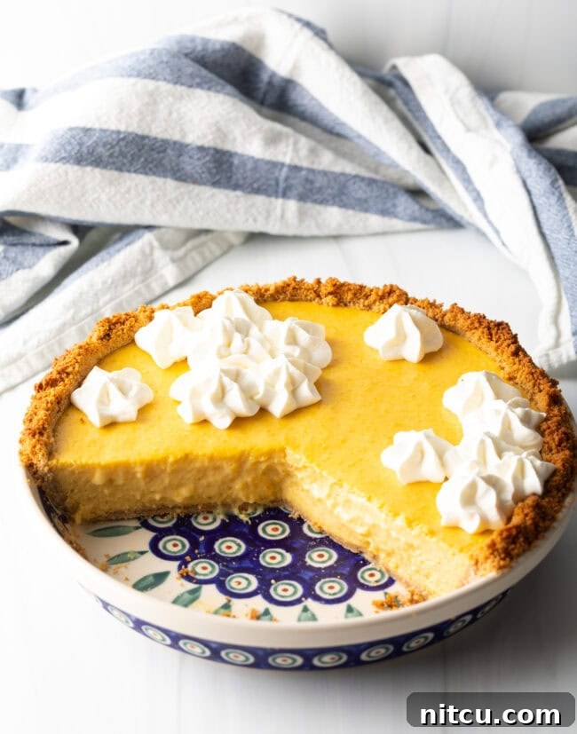 A mango pie with a third portion removed, showcasing the beautifully set custard and crisp crust, ready to be enjoyed.