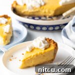 Slices of golden mango pie on a white plate, with a metal fork resting beside them.