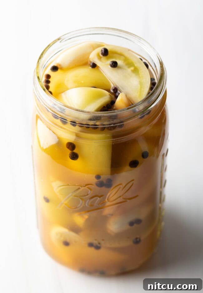 Tangy Tomato Preserves 12 Marinated pickled green peppers in a large glass jar.