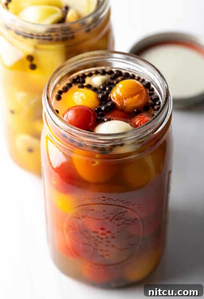 Tangy Tomato Preserves 3 Marinated pickled cherry tomatoes in a large glass jar.