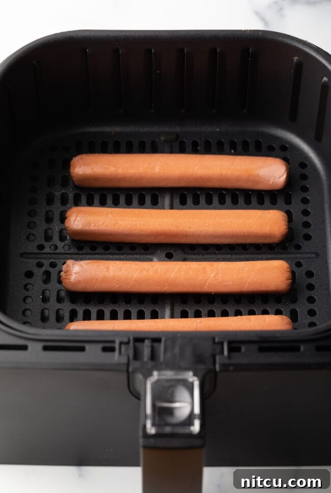 Crispy Air-Fried Franks 5 Top down four hot dogs in air fryer basket.