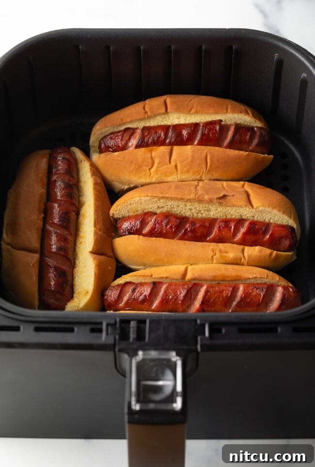 Crispy Air-Fried Franks 7 Toasting four hot dogs in buns in an air fryer.