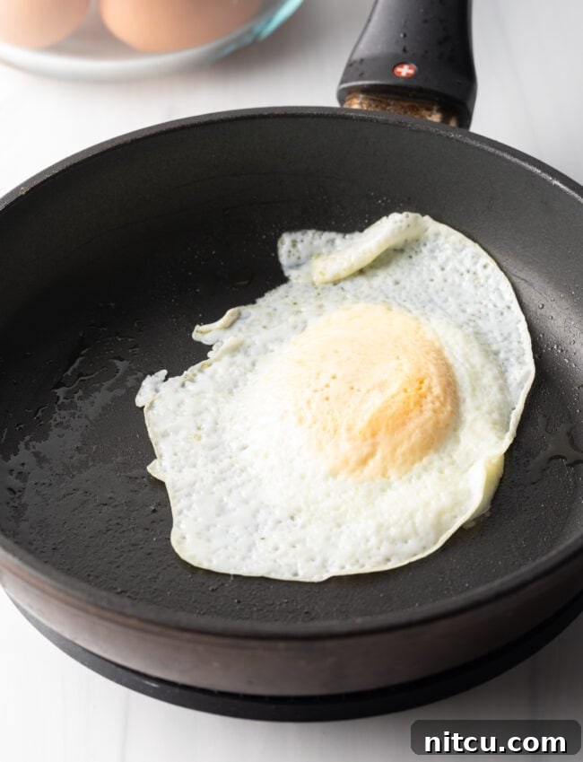 Mastering Over Easy Eggs 10 Soft fried egg over easy in a black nonstick skillet.