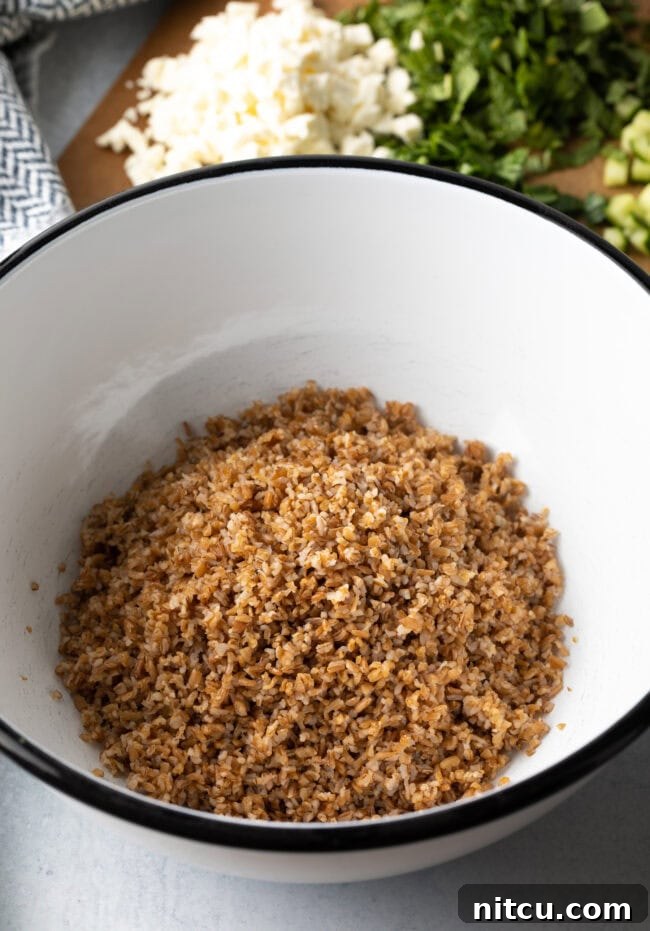 Jennifer Aniston's Go-To Bulgur Salad 6 Large white salad bowl with cooked bulgur wheat.