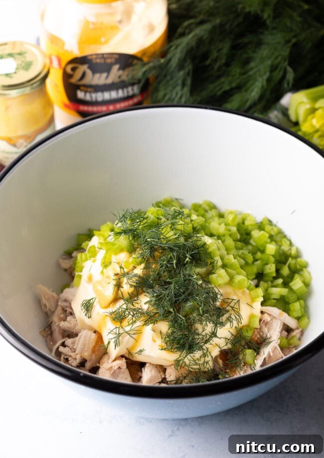 Perfect Turkey Sandwich Salad 6 White bowl with shredded poultry, mayo, celery, and fresh dill.