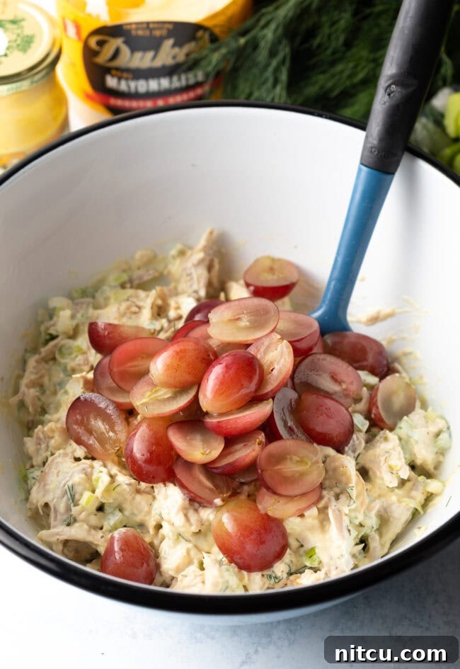 Perfect Turkey Sandwich Salad 7 Adding halved grapes to the bowl.
