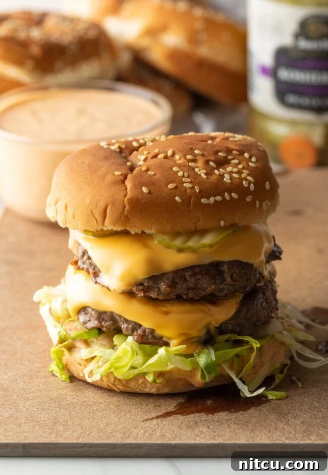 A perfectly stacked double-patty Big Mac burger, homemade and sitting on a wooden cutting board.