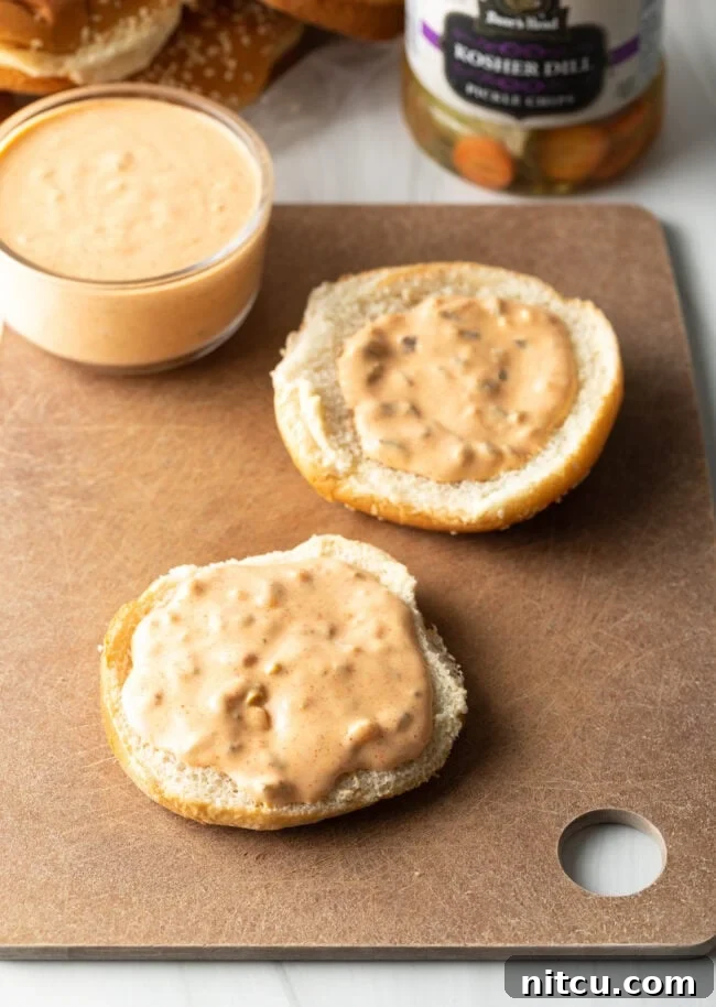Two halves of hamburger buns, opened up and each coated with a generous smear of Big Mac sauce.