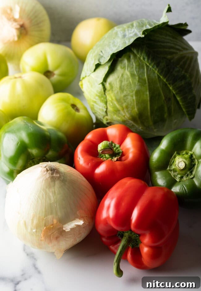 Tangy Homemade Chow Chow 4 Recipe ingredients: Fresh red bell peppers, green pepper, tomatillos, white onion, and cabbage.