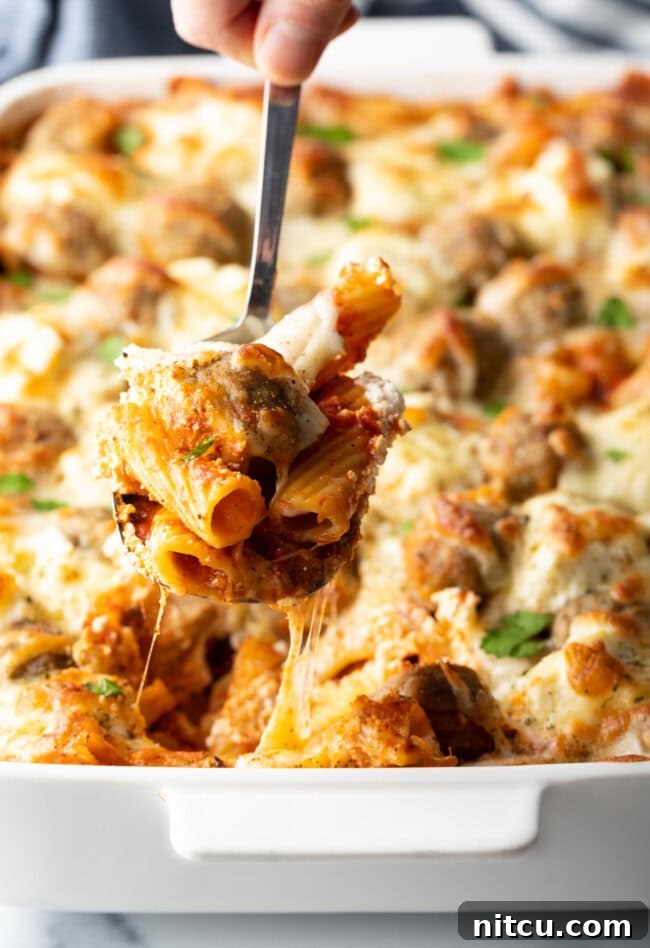 One-Pan Meatball Casserole 2 Metal spoon holding a serving of meatball casserole to camera.
