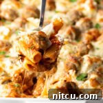 One-Pan Meatball Casserole 13 Metal spoon holding a serving of meatball casserole to camera.