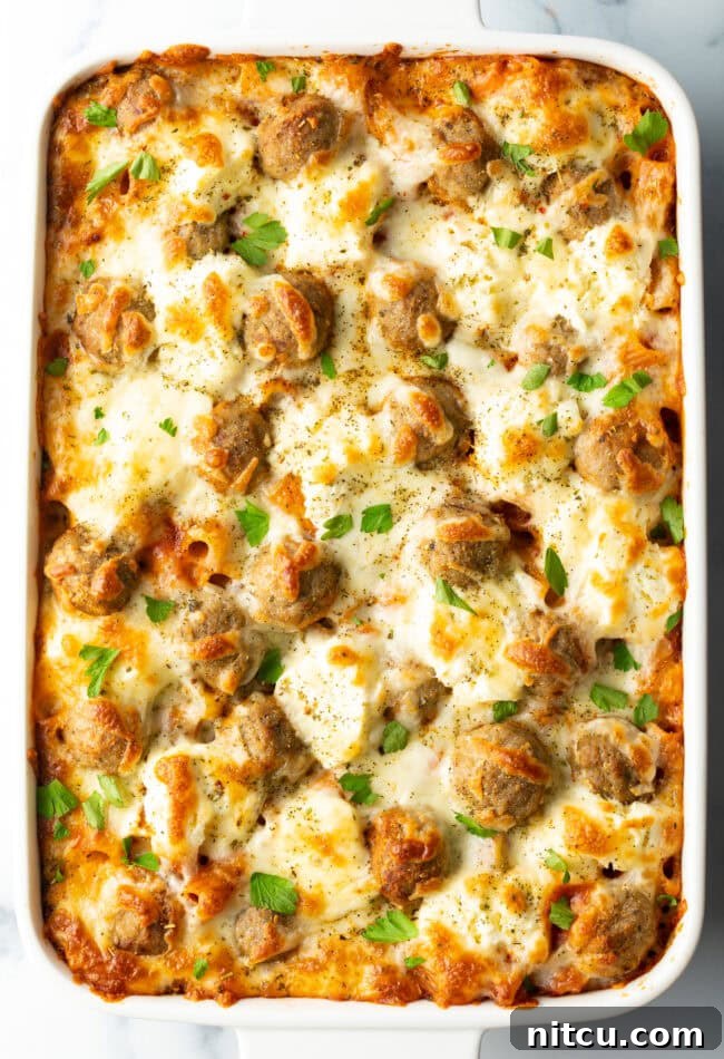 One-Pan Meatball Casserole 3 Baked meatball casserole in a white dish, bubbly cheese on top.
