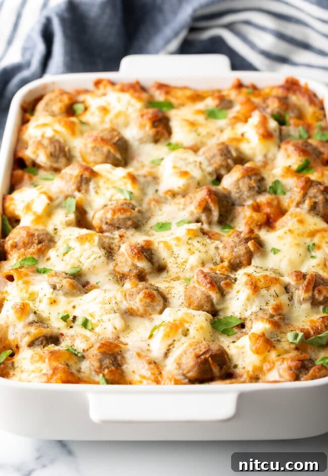 One-Pan Meatball Casserole 9 Baked dump and bake meatball casserole in a white dish, bubbly cheese on top.