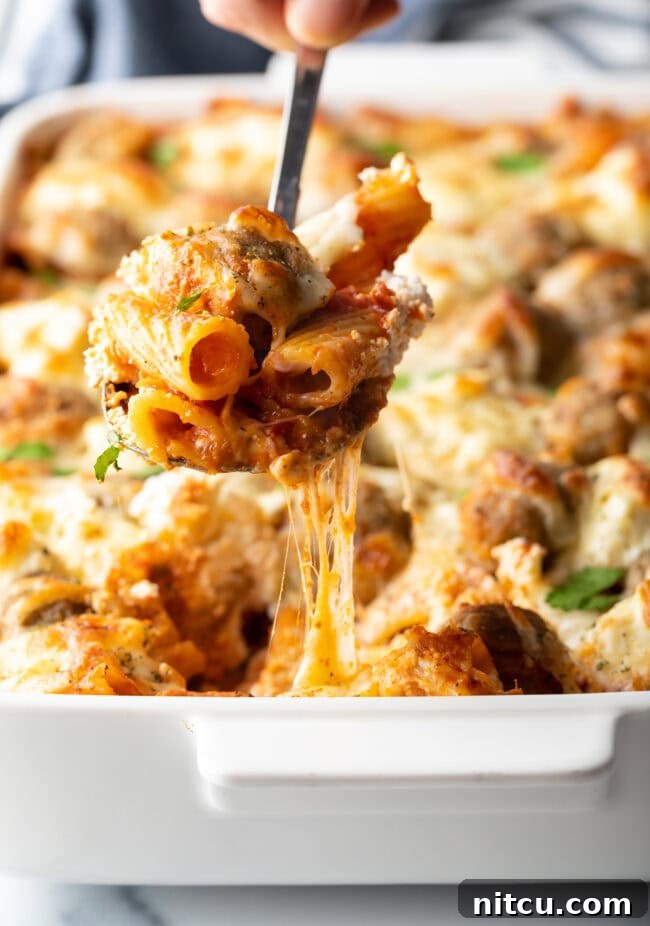One-Pan Meatball Casserole 10 Metal spoon holding a serving of dump and bake meatball casserole to camera.