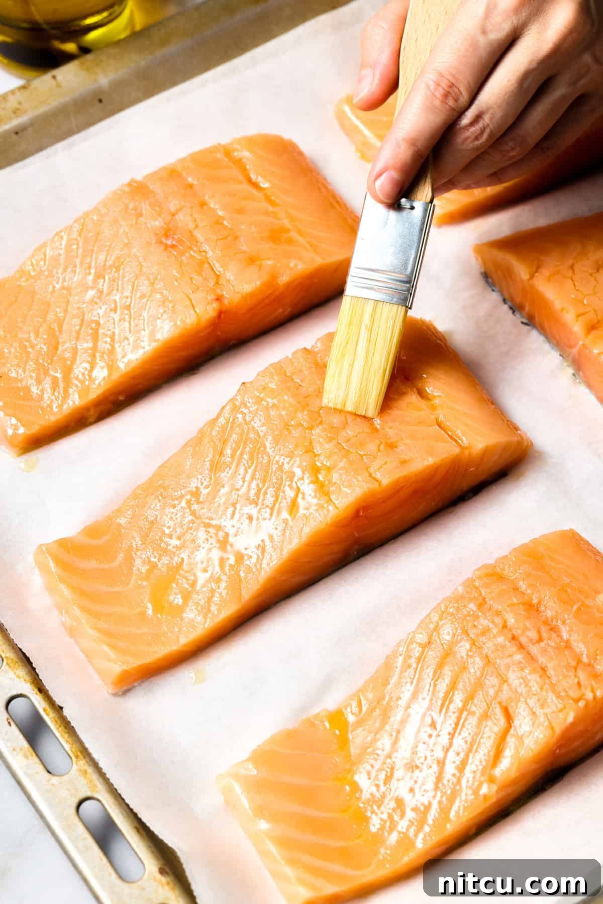 Pink Peppercorn #ASpicyPerspective #Salmon #RoastedSalmon #OvenRoastedSalmon #RoastedSalmonRecipe #PeppercornSauce #PinkPeppercorn #PinkPeppercornSauce #MothersDay Brushing salmon with oil for roasting