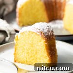 Slice of yellow cake on a white plate.