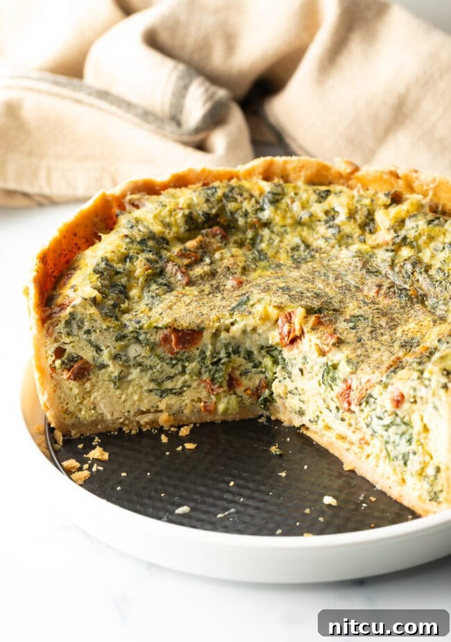 Garden Medley Deep Dish Quiche 3 Close-up of a deep dish vegetarian quiche cooling, showing the tall, golden-brown crust and vibrant filling.