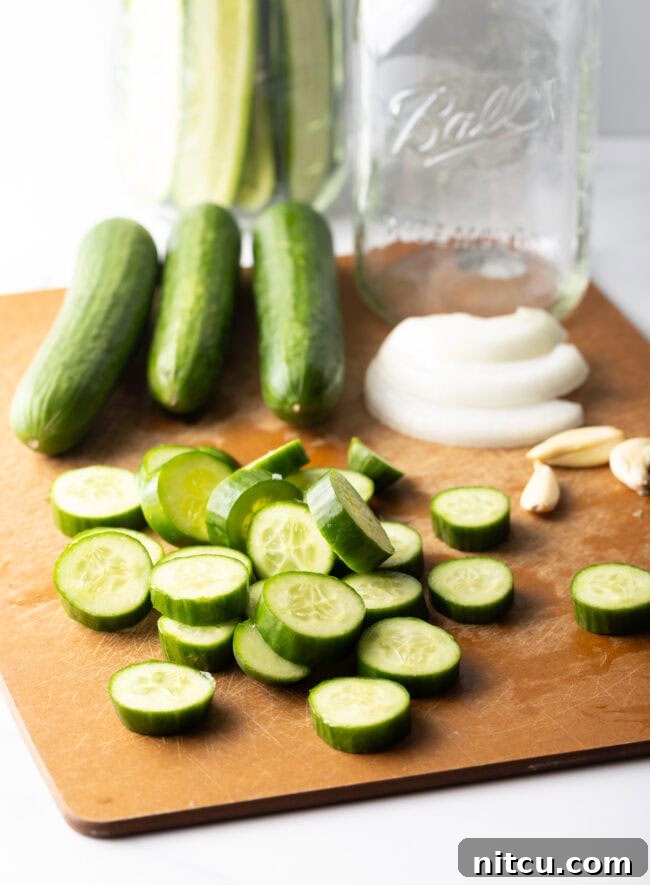 Chamoy Drenched Pickles 6 Wood cutting board with several small cucumbers, several sliced into thin rounds.