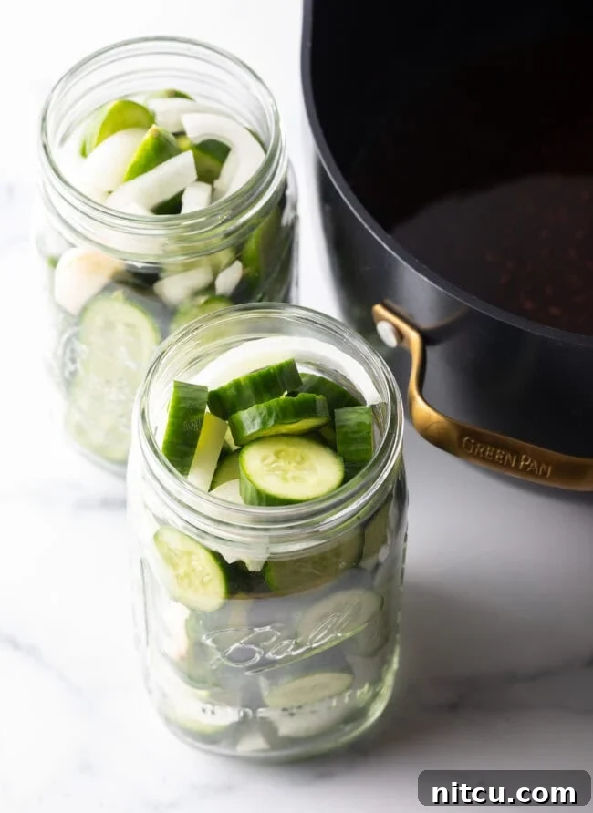 Chamoy Drenched Pickles 7 Cucumbers sliced into discs and filled into two large glass jars.