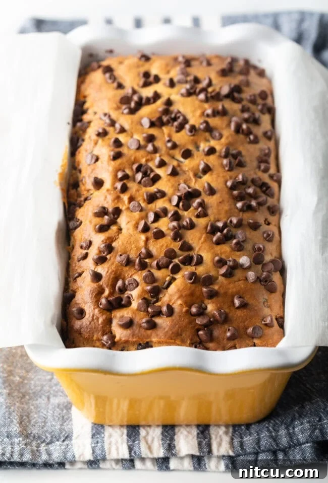 Ice cream bread with chocolate chips in a yellow ceramic baking pan loaf.