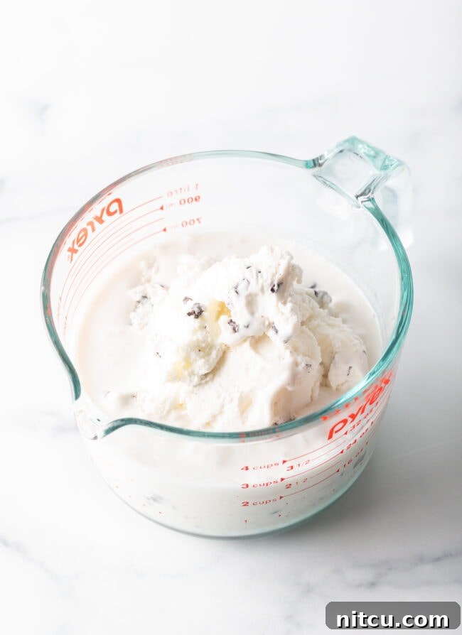 Ice cream melting in a large glass measuring bowl.