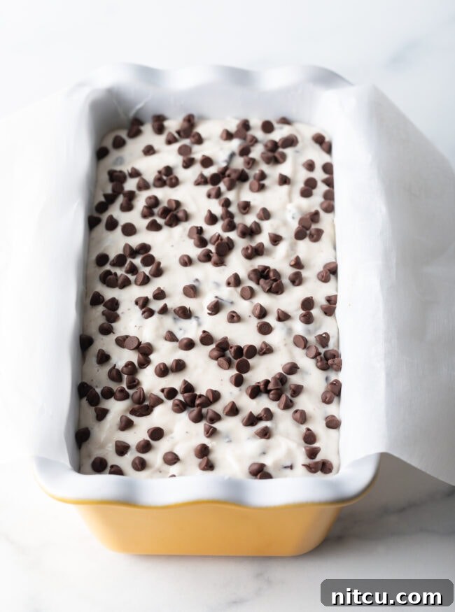 Batter in a yellow ceramic baking pan loaf.