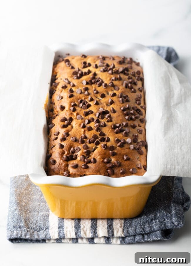 Ice cream bread with chocolate chips in a yellow ceramic baking pan loaf.