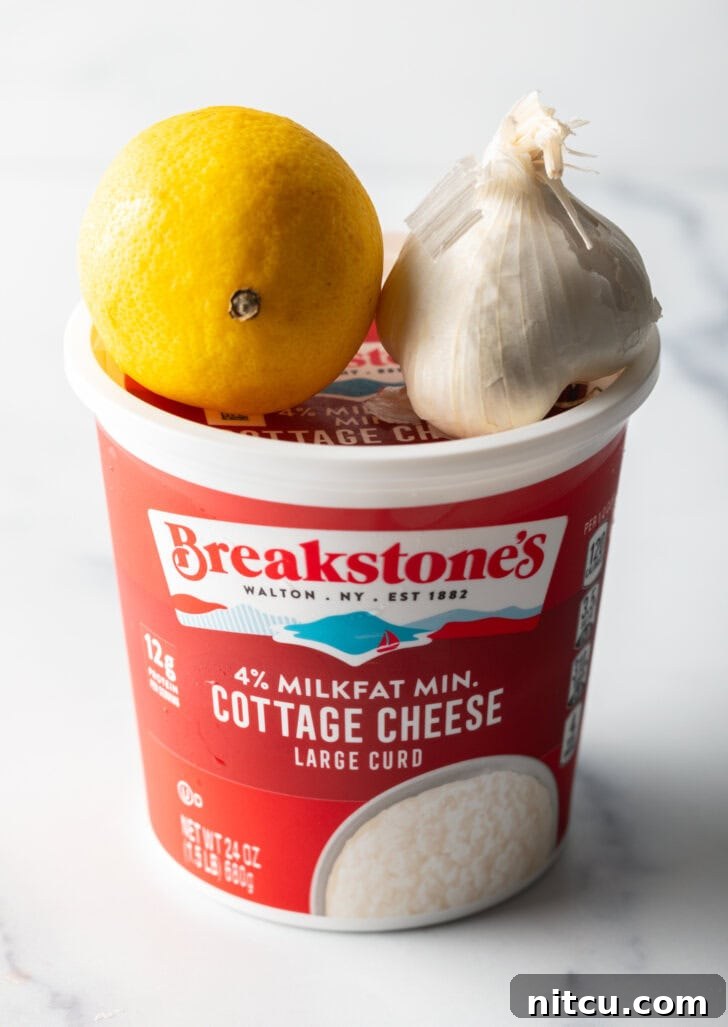 Recipe ingredients: Tub of cottage cheese with a whole lemon and head of garlic balanced on top.