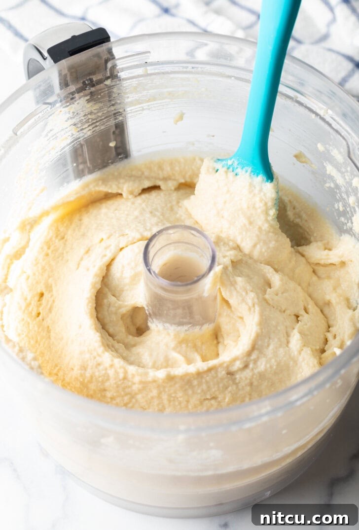 Wholesome Cookie Dough Delight 5 Blue spatula swishing cottage cheese cookie dough through a food processor.