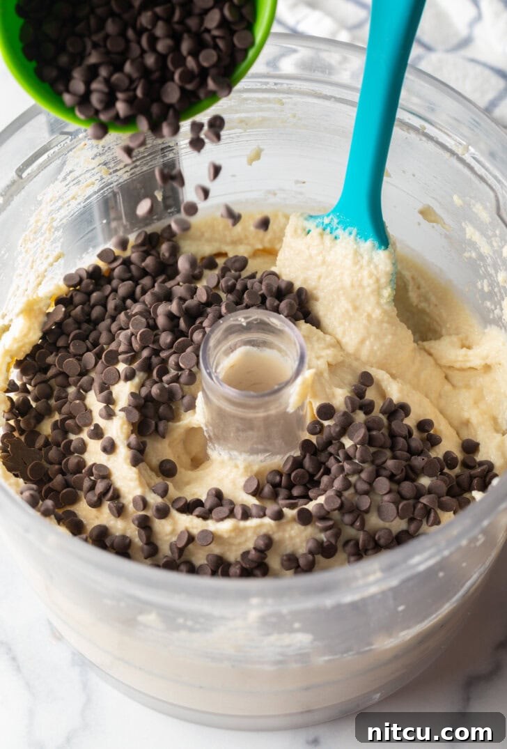 Wholesome Cookie Dough Delight 7 Adding chocolate chips to the food processor with cookie dough.