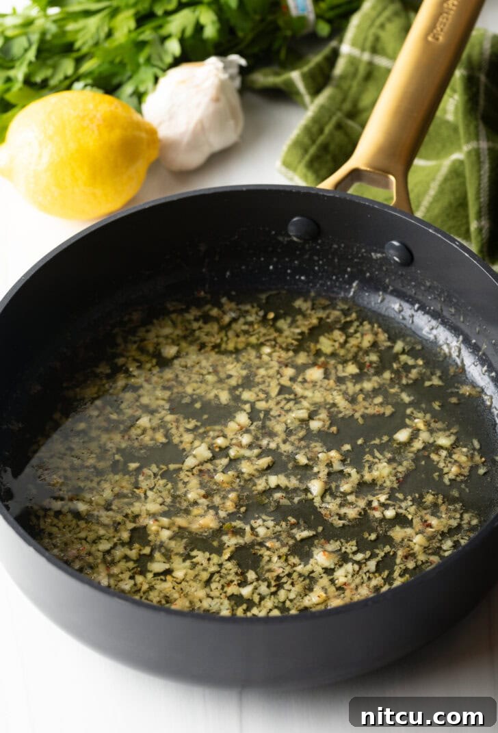 Irresistible Garlic Butter Noodles 5 Butter and minced garlic in a black skillet.