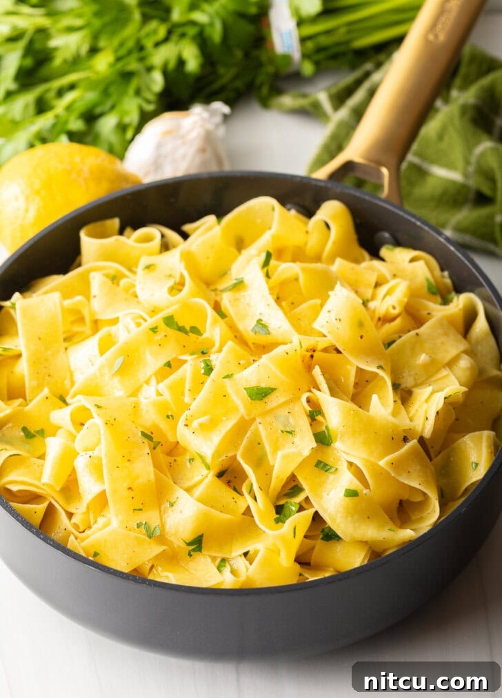 Irresistible Garlic Butter Noodles 8 Black skillet with cooked garlic butter noodles.
