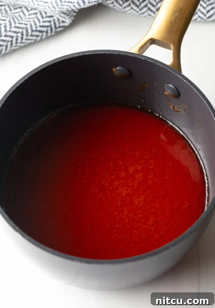 The Best Homemade Buffalo Wing Sauce 6 Black sauce pot with red wing sauce.
