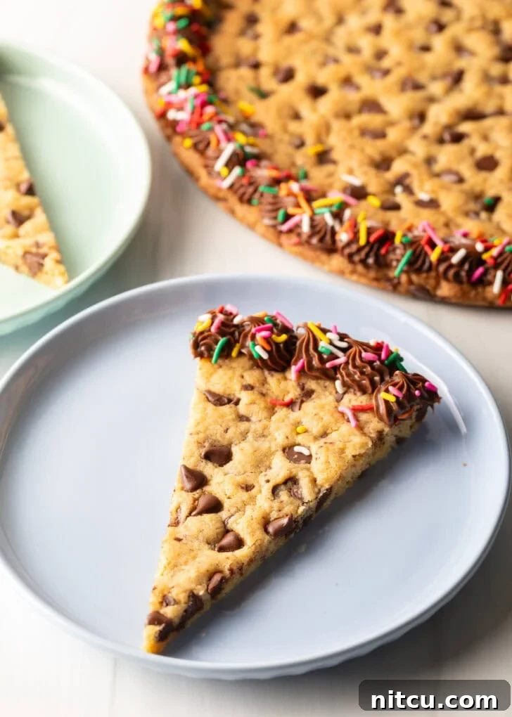Ultimate Chocolate Chip Cookie Cake 4 One triangle slice of homemade cookie cake on a pastel blue plate.