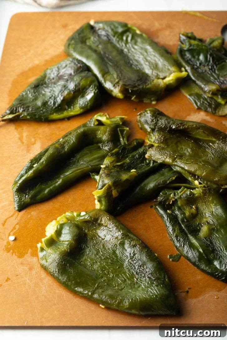 8 roasted poblano pepper on a cutting board, seeds having been removed.