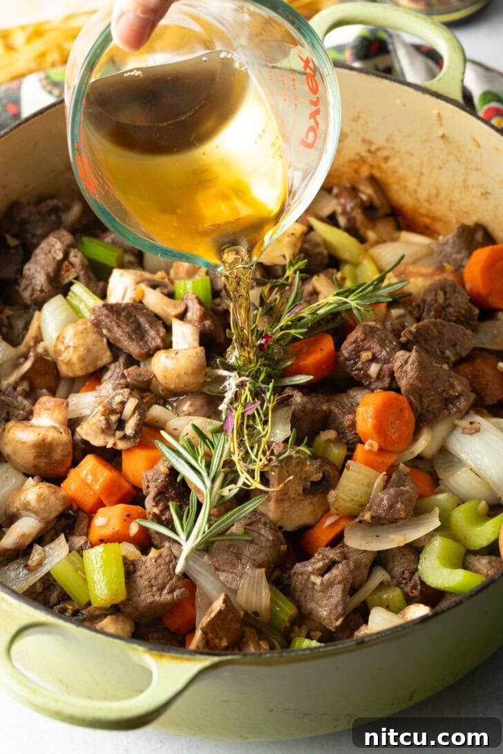 Ultimate Beef Noodle Soup 6 Searing beef chunks and veggies in a large cooking pot. Adding sprigs. Pouring in broth
