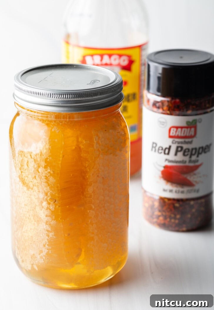 Recipe ingredients in separate container: jar of honey, shaker of crushed red pepper, bottle of apple cider viegar.