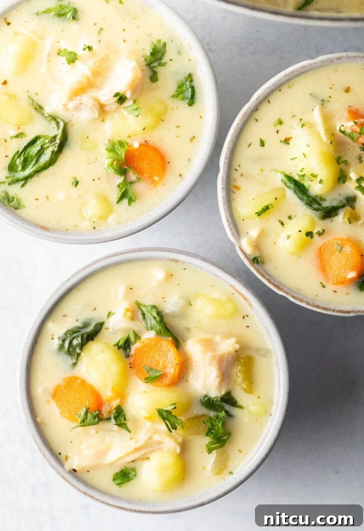 Another view of three inviting white bowls filled with the delightful chicken gnocchi soup, perfect for a cozy meal.