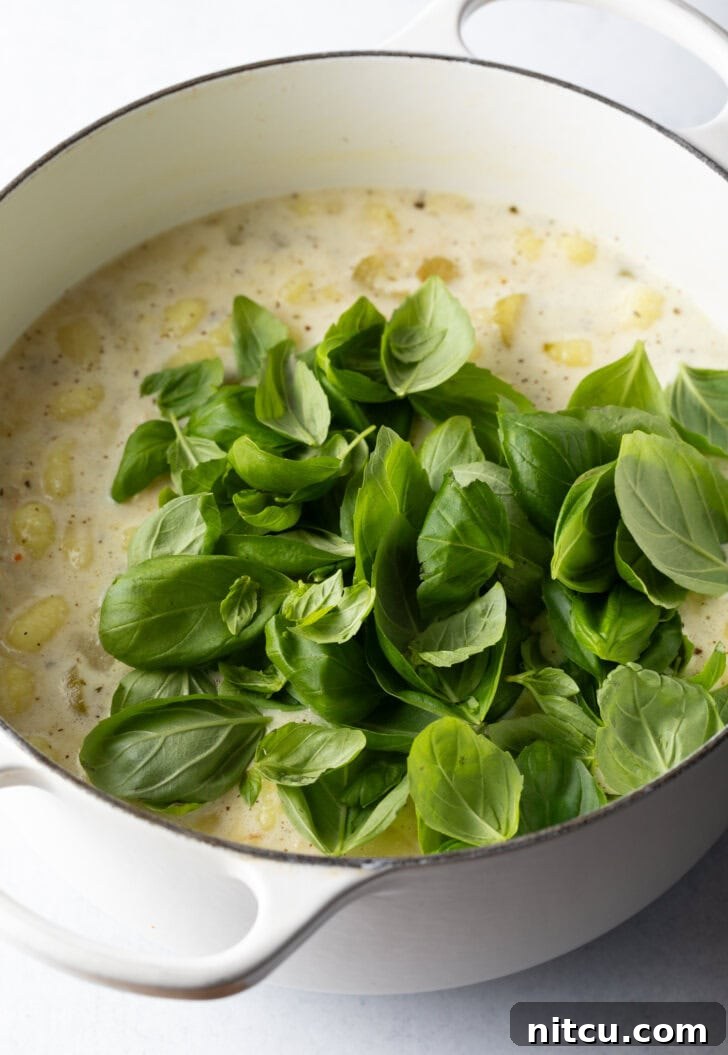 Fresh spinach leaves being gently added into the hot cooking pot, adding vibrant color and nutrients to the soup.