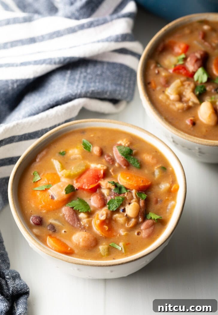 Two white bowls of 15 bean soup.