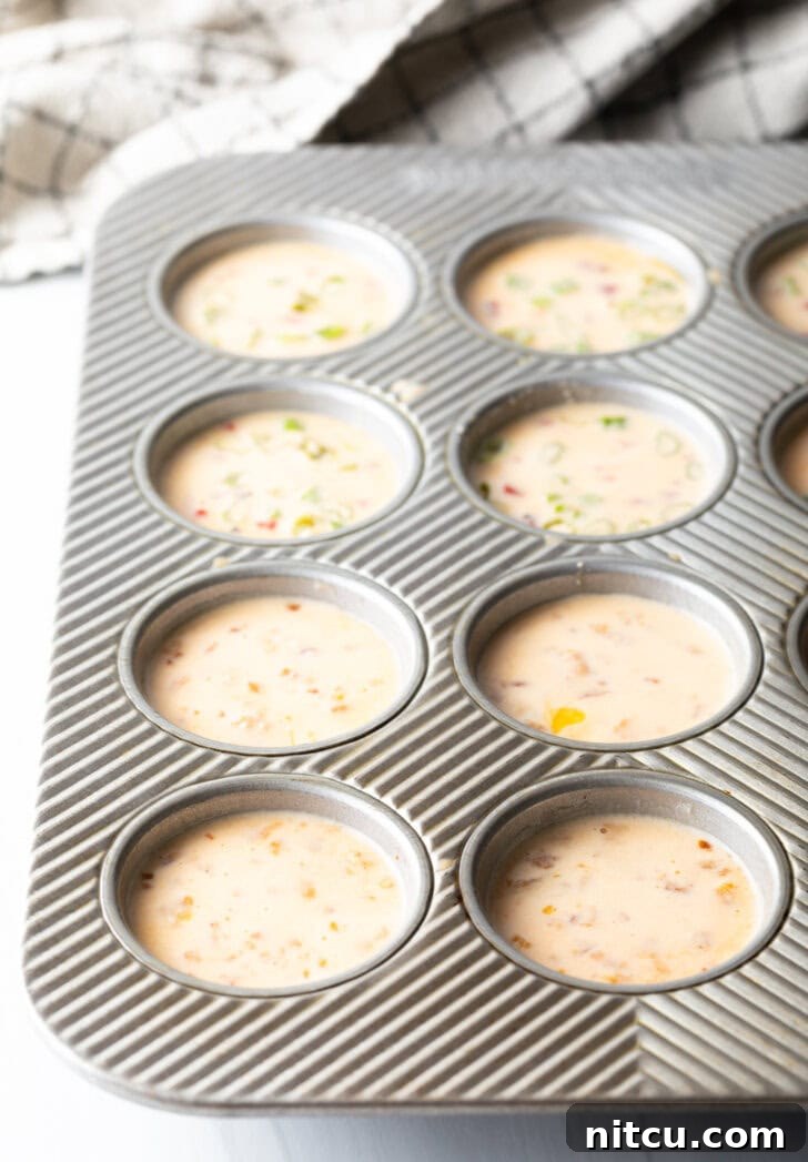 Effortless Egg Bites 7 A metal muffin tin holds 12 portions of raw egg blend, ready for baking.