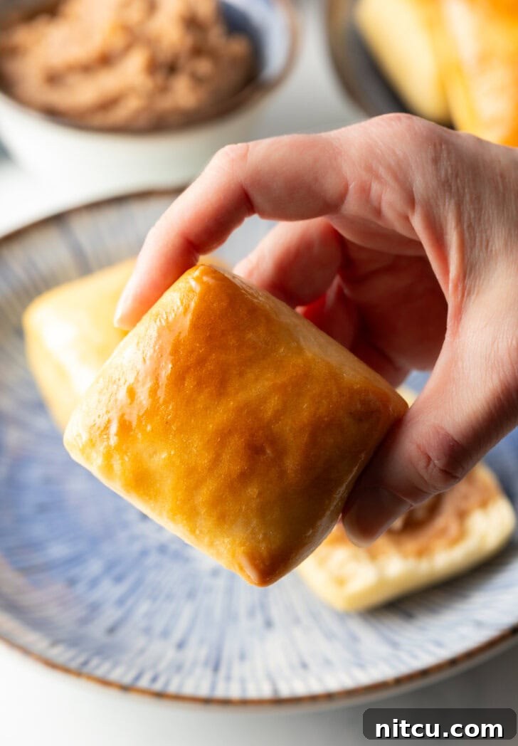 Hand holding a Texas road house yeast roll to camera.