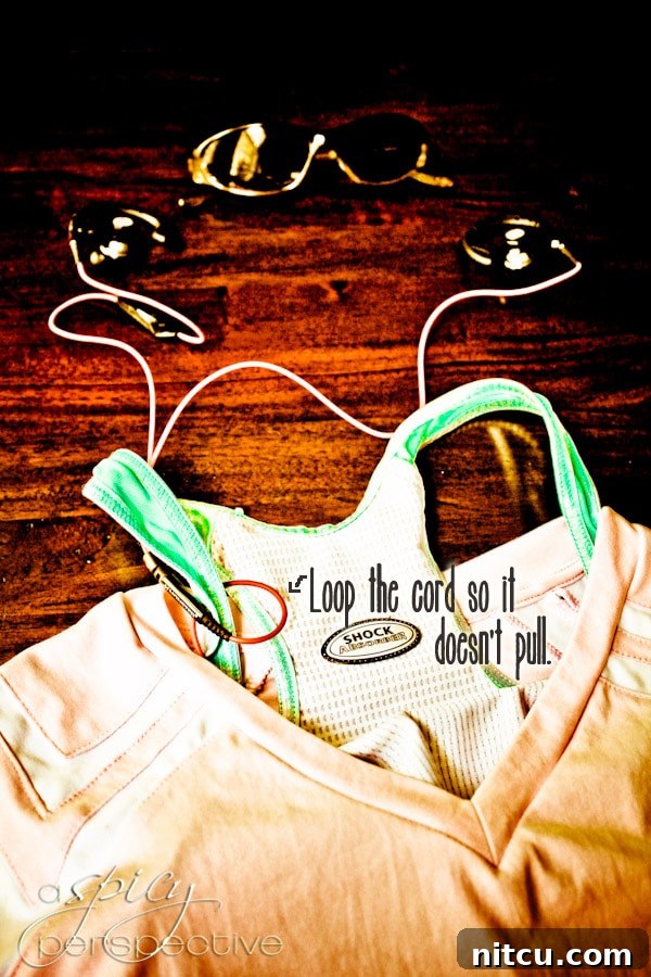 Running Tip: Secure All Cords for a Distraction-Free Run A detailed shot showing how to loop a headphone cord around a sports bra for security during a run.