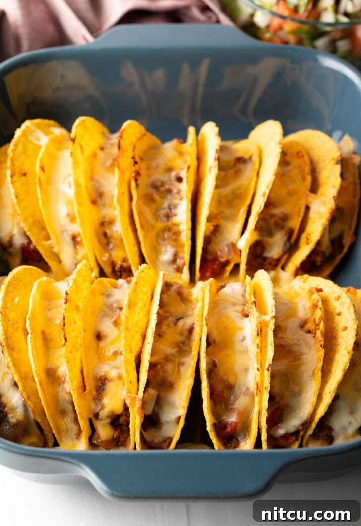 Effortless Baked Tacos 8 Melted cheese bubbling over the rows of tacos in the baking dish, just out of the oven.