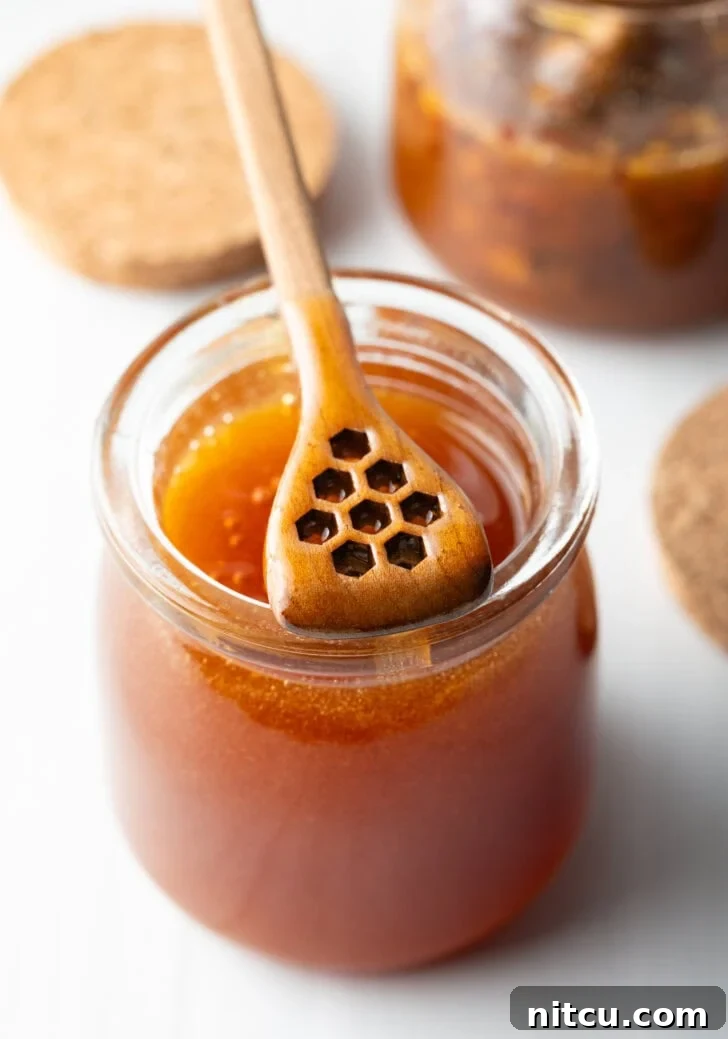 Sweet Heat Chicken 5 A vibrant spread of ingredients for Hot Honey Chicken, neatly arranged on a rustic wooden surface, including fresh chicken breasts, pickle juice, flour, cornstarch, various spices, milk, eggs, and a prominent jar of honey.