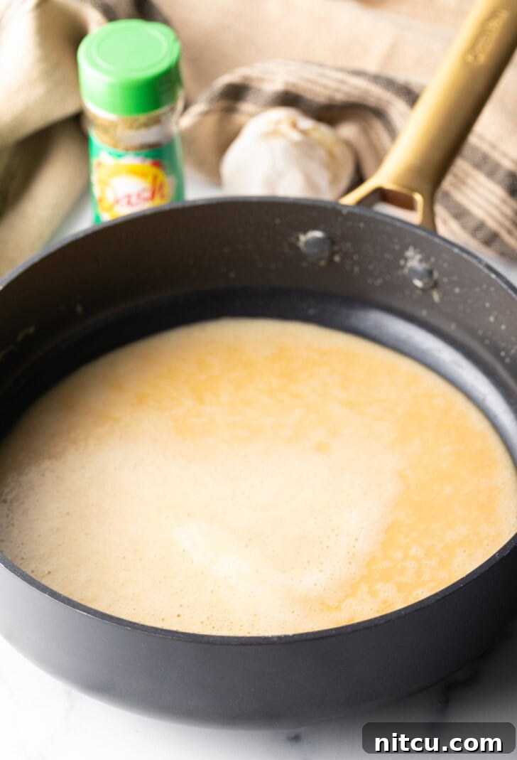 Deep skillet with a golden-brown sauce roux, the foundation for the creamy sauce.