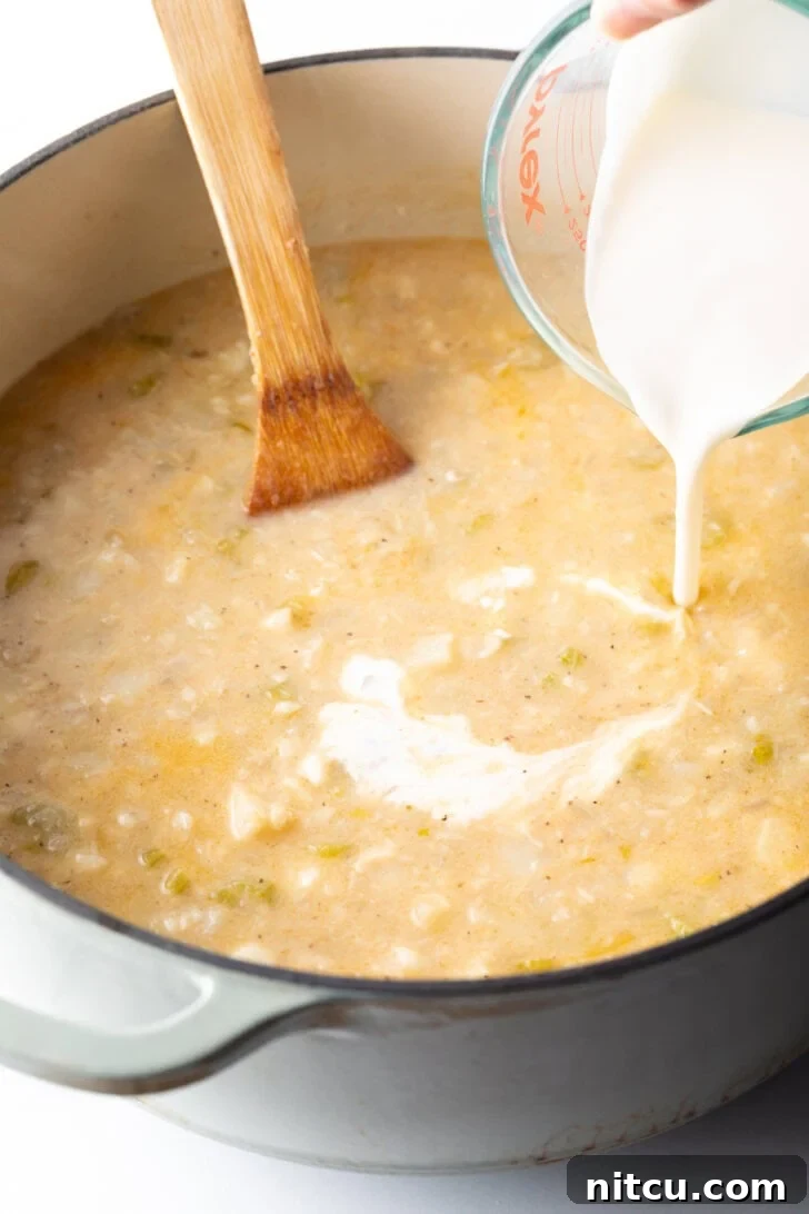 Hearty Seafood Chowder 7 Adding cream to the soup base.