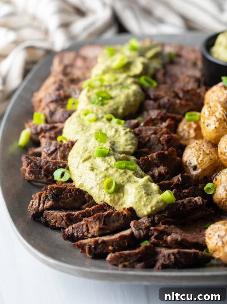Signature London Broil Marinade 13 London broil sliced into thick strips, covered with rich green sauce and chopped scallions with baby potatoes on the side.