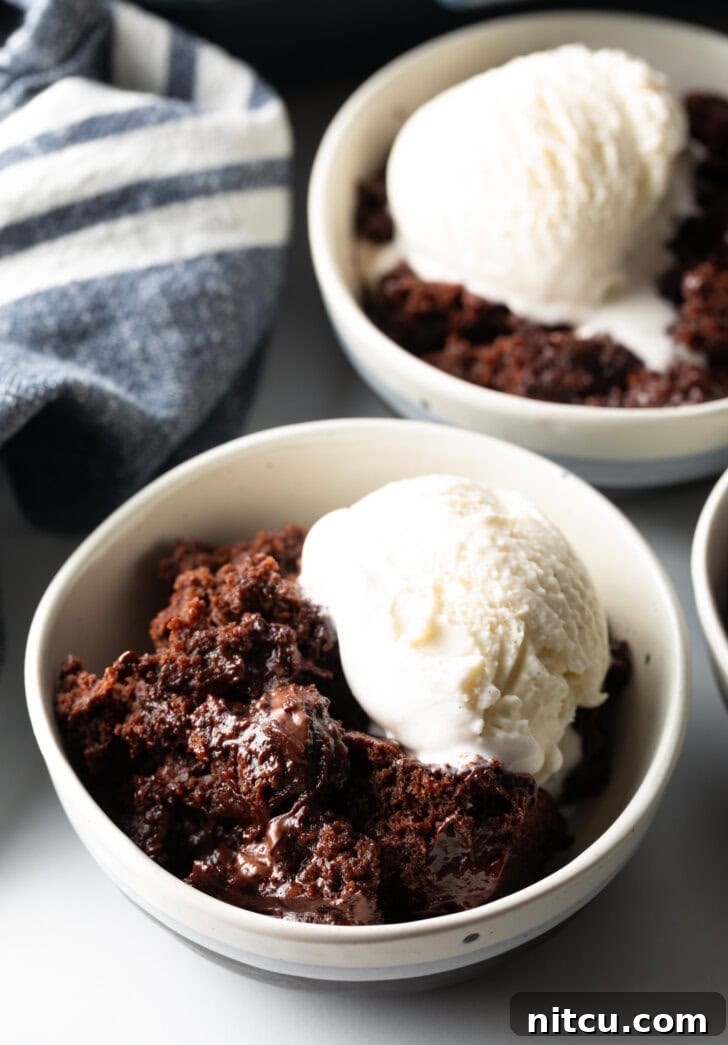 Decadent Chocolate Pudding Cake 12 White bowl with serving of chocolate lava cake and a scoop of vanilla ice cream.